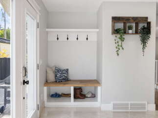 Welcome guests into a bright and organized entryway featuring a charming built-in bench with ample storage for shoes and accessories.