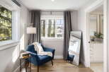 Step into this inviting space featuring a comfortable blue armchair perfect for reading, complemented by a stylish floor lamp and a side table with books.