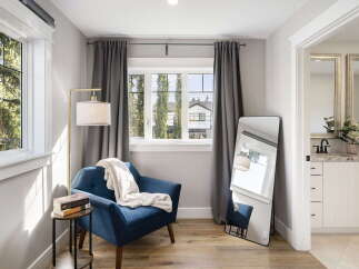 Step into this inviting space featuring a comfortable blue armchair perfect for reading, complemented by a stylish floor lamp and a side table with books.