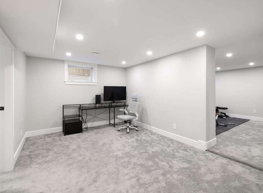 Discover this beautifully finished basement, offering a versatile space for work and fitness.