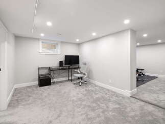Discover this beautifully finished basement, offering a versatile space for work and fitness.