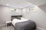 Discover comfortable living in this charming bedroom, featuring a cozy bed with plush grey pillows and a soft blanket.