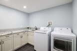 This spacious laundry room features a top-load washing machine and a front-load dryer, perfect for handling large loads.