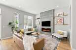 Experience modern living in this stylish living room featuring a sleek fireplace and a large television mounted above it.