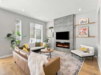 Experience modern living in this stylish living room featuring a sleek fireplace and a large television mounted above it.