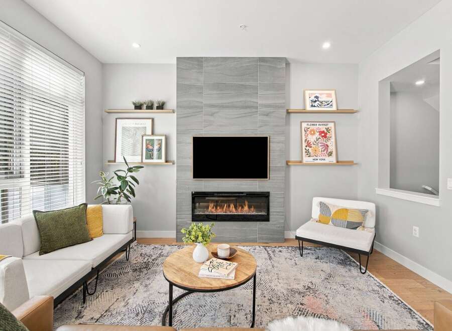 Experience modern living in this beautifully appointed living room, featuring a sleek fireplace as the focal point and a large television for entertainment.