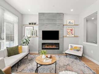 Experience modern living in this beautifully appointed living room, featuring a sleek fireplace as the focal point and a large television for entertainment.