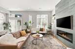 Experience modern living in this stylish living room, featuring a comfortable brown leather sofa adorned with a plush white throw and accent pillows.