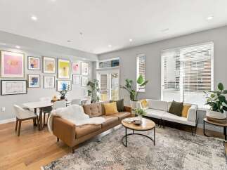 Experience modern living in this spacious open-concept living and dining area, featuring a stylish leather sofa, a comfortable white sectional, and a chic marble-top dining table.