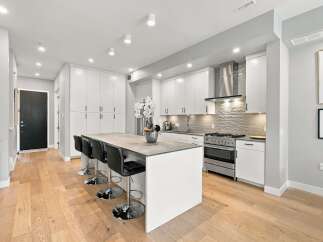 Experience modern living in this stunning kitchen featuring sleek white cabinetry and a spacious island perfect for entertaining.