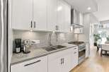 Discover this modern kitchen featuring sleek white cabinetry and a stylish grey subway tile backsplash.