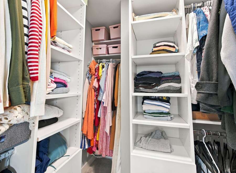 Discover organized living with this spacious walk-in closet, featuring ample shelving and hanging space for all your clothing needs.