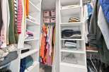 Discover organized living with this spacious walk-in closet, featuring ample shelving and hanging space for all your clothing needs.