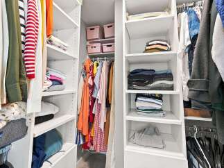 Discover organized living with this spacious walk-in closet, featuring ample shelving and hanging space for all your clothing needs.