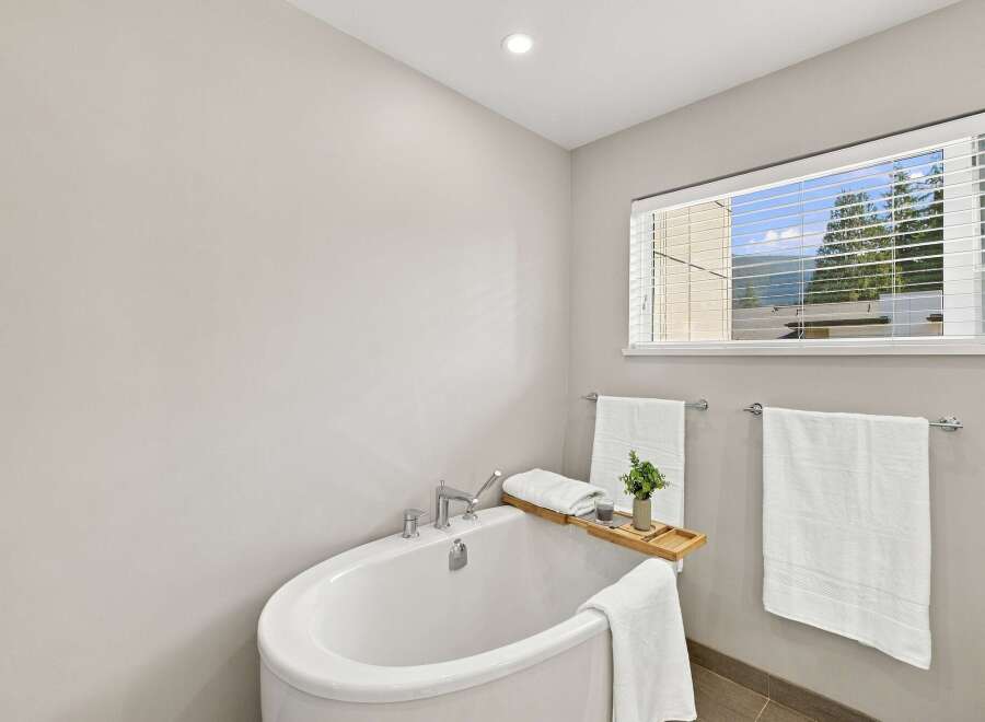 Indulge in relaxation in this serene bathroom, featuring a luxurious freestanding bathtub perfect for unwinding.