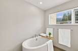 Indulge in relaxation in this serene bathroom, featuring a luxurious freestanding bathtub perfect for unwinding.