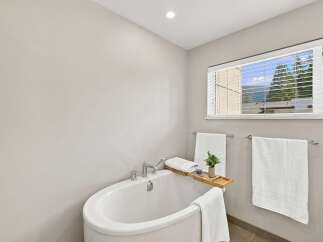Indulge in relaxation in this serene bathroom, featuring a luxurious freestanding bathtub perfect for unwinding.