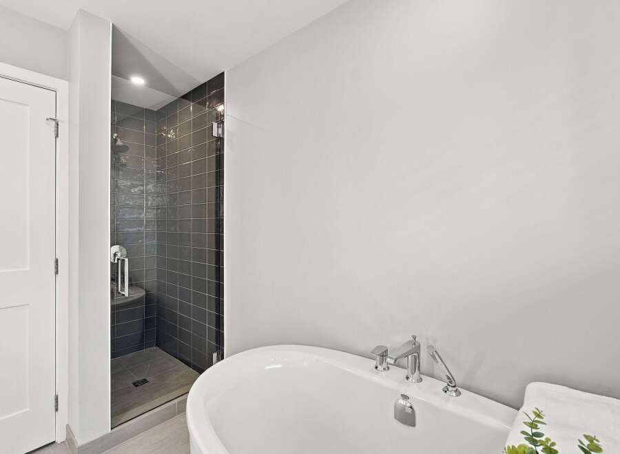 Experience modern luxury in this stunning bathroom featuring a sleek, glass-enclosed shower with dark tiled walls and a rainfall showerhead.