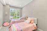 This charming children's bedroom features two twin beds adorned with pink quilted bedding and playful stuffed animals.