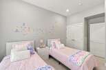 This charming bedroom features two twin beds with plush pink bedding, perfect for a child's or guest room.