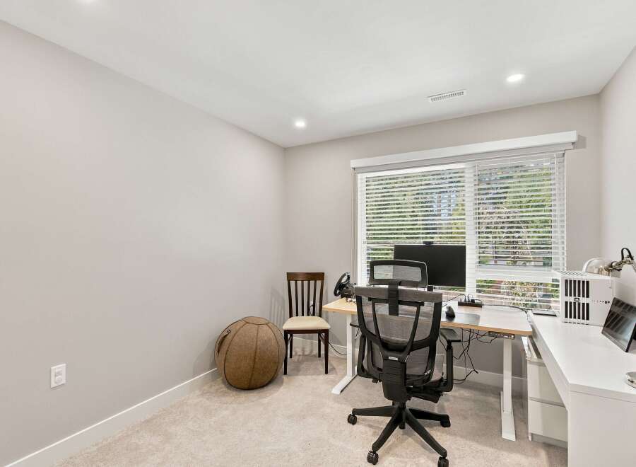 This home office features a spacious desk with a computer setup, perfect for remote work or study.