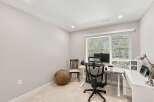 This home office features a spacious desk with a computer setup, perfect for remote work or study.