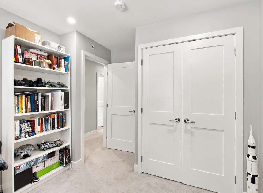 Discover this inviting space featuring a tall white bookshelf filled with books and decorative items, perfect for organizing your collection.