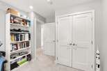 Discover this inviting space featuring a tall white bookshelf filled with books and decorative items, perfect for organizing your collection.
