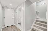 Step into this welcoming entryway featuring a sleek white door and a full-length mirror, perfect for last-minute checks.