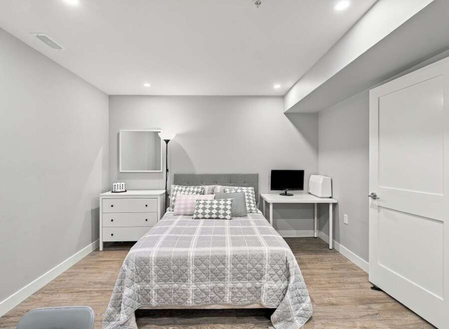 Discover this charming bedroom featuring a comfortable bed with a stylish headboard, complemented by a modern dresser and a convenient desk area.