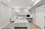 Discover this charming bedroom featuring a comfortable bed with a stylish headboard, complemented by a modern dresser and a convenient desk area.