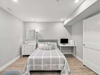 Discover this charming bedroom featuring a comfortable bed with a stylish headboard, complemented by a modern dresser and a convenient desk area.