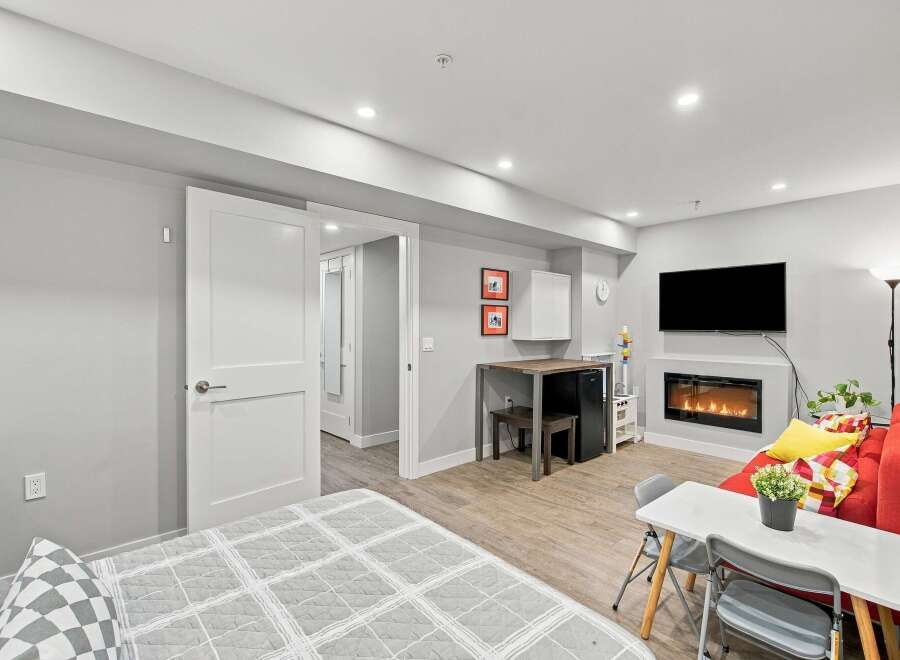 Discover modern living in this stylish studio apartment, featuring a cozy fireplace and a sleek entertainment area.