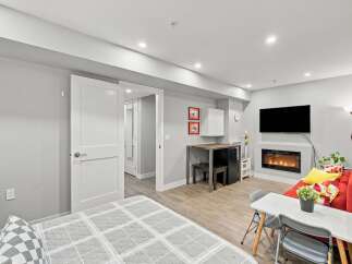 Discover modern living in this stylish studio apartment, featuring a cozy fireplace and a sleek entertainment area.