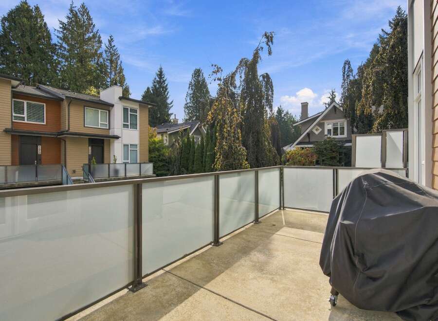 Enjoy outdoor living on this spacious balcony, complete with a modern glass railing offering unobstructed views.