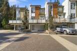 Experience modern living in this stunning townhouse featuring a sleek contemporary design with a mix of green and wood-paneled exteriors.
