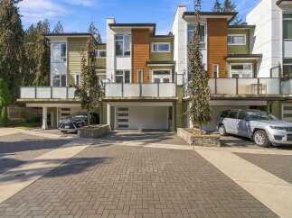 Experience modern living in this stunning townhouse featuring a sleek contemporary design with a mix of green and wood-paneled exteriors.