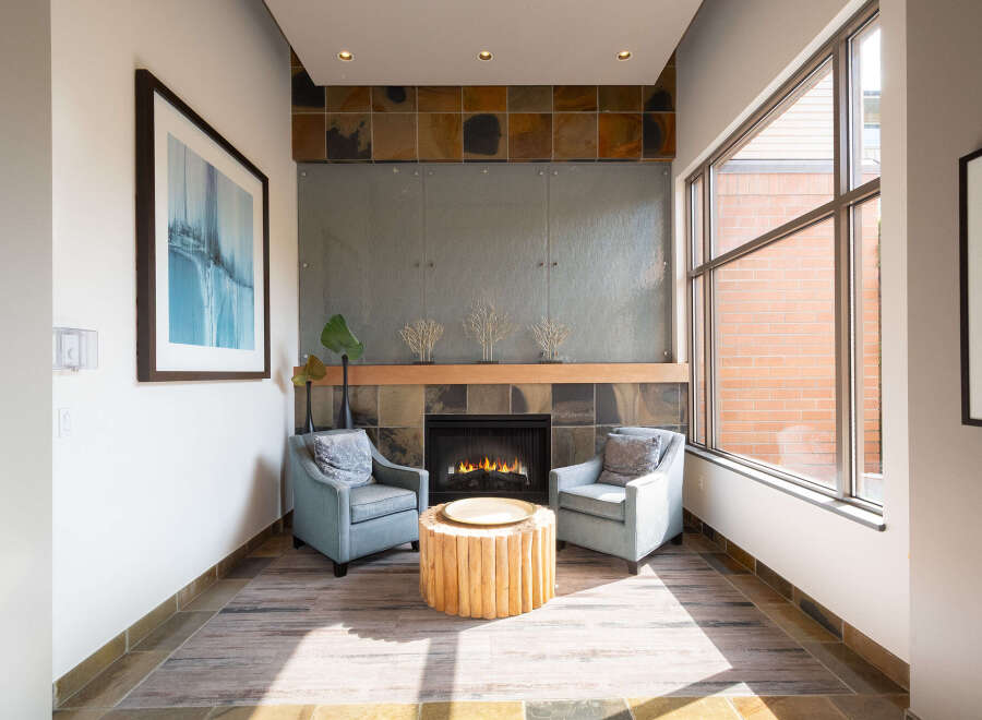 Experience modern comfort in this inviting living space, featuring a cozy fireplace as the focal point.