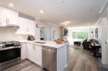 Experience modern living in this beautifully renovated condo featuring a sleek white kitchen with stainless steel appliances and a spacious island perfect for entertaining.