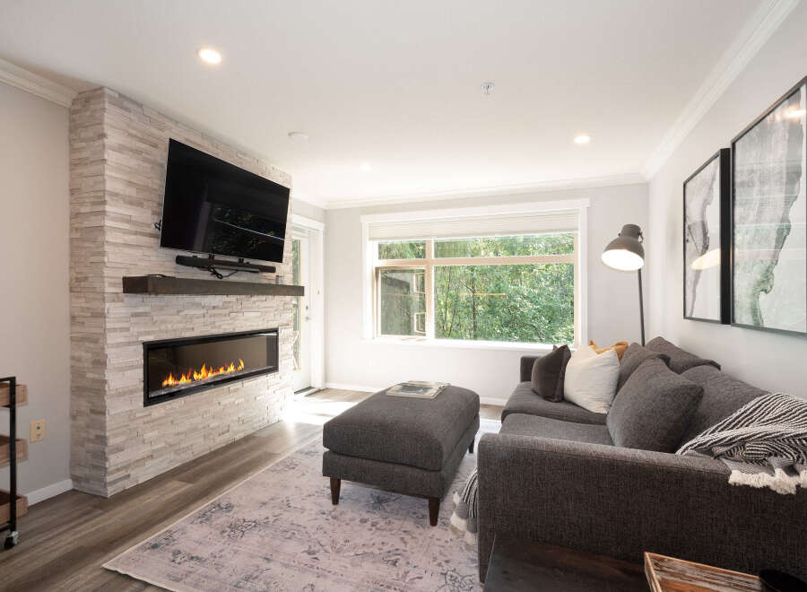 Experience modern living in this stylish living room, featuring a sleek gas fireplace set against a textured stone accent wall.