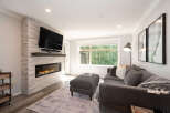 Experience modern living in this stylish living room, featuring a sleek gas fireplace set against a textured stone accent wall.