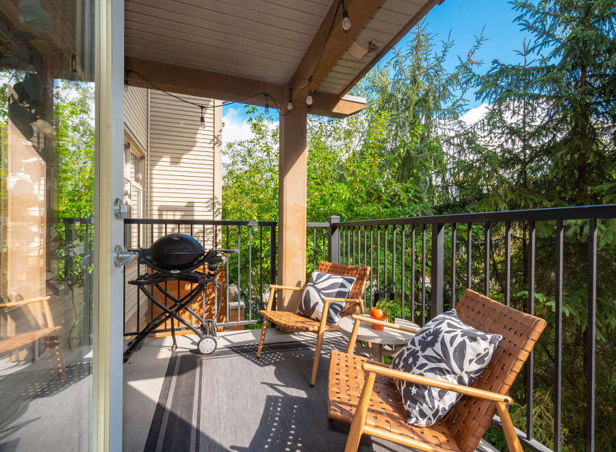 Enjoy outdoor living on this charming balcony, complete with a grill for summer cookouts and comfortable seating for relaxation.