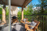 Enjoy outdoor living on this charming balcony, complete with a grill for summer cookouts and comfortable seating for relaxation.