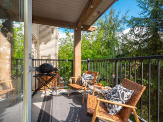 Enjoy outdoor living on this charming balcony, complete with a grill for summer cookouts and comfortable seating for relaxation.
