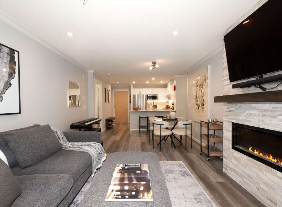 Experience modern living in this open-concept space featuring a sleek kitchen with stainless steel appliances and a dining area perfect for intimate meals.