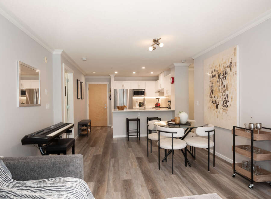 Experience modern living in this bright and airy open-concept space, featuring a sleek kitchen with stainless steel appliances and ample cabinet space.
