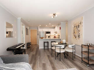 Experience modern living in this bright and airy open-concept space, featuring a sleek kitchen with stainless steel appliances and ample cabinet space.