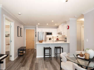 Discover modern living in this beautifully appointed condo, featuring a sleek, open-concept kitchen with stainless steel appliances and a spacious island perfect for entertaining.