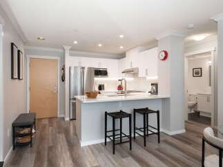 Discover modern living in this stylish condo featuring a sleek kitchen with stainless steel appliances and a convenient breakfast bar.