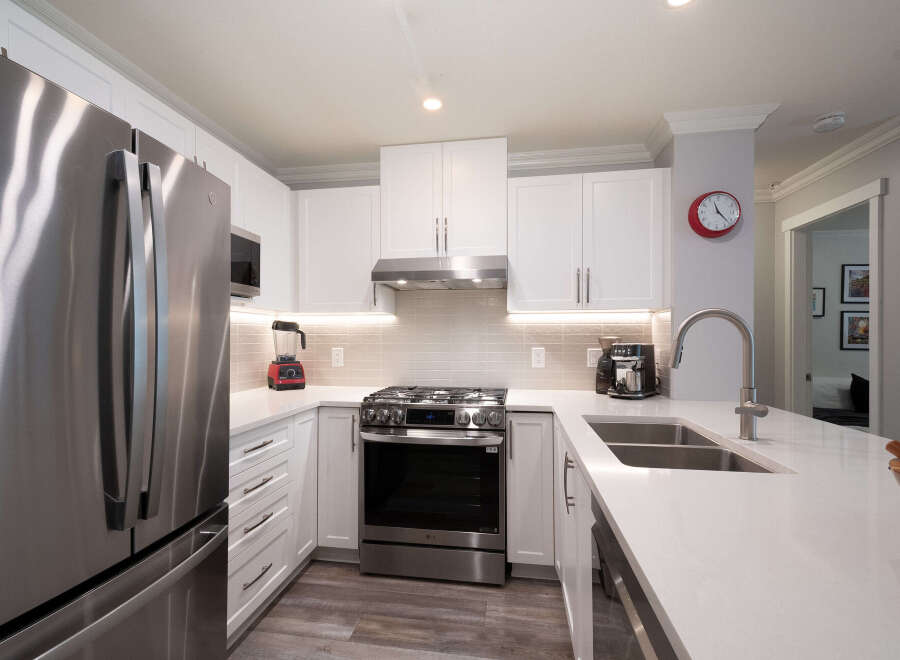 Experience modern living in this stunning kitchen featuring sleek stainless steel appliances, including a French door refrigerator and a gas range.